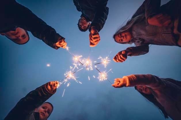 Five children holding sprklers against evening sky model released Symbolfoto OCMF01086