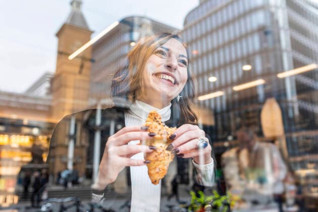 Happy businesswoman having a snack at a cafe in the city model released Symbolfoto  WPEF02782