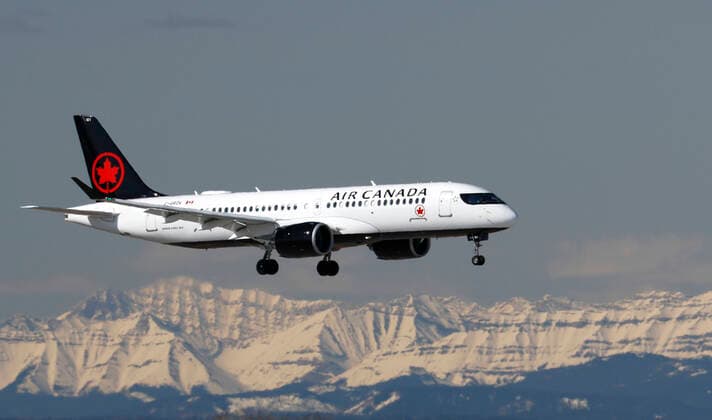 An Airbus A220 (A220-300) jetliner, belonging to Air Canada, lands in Calgary, Alberta, Canada on Apr. 24, 2020. In the background are the Rocky Mountains. digital photo by Larry MacDougal