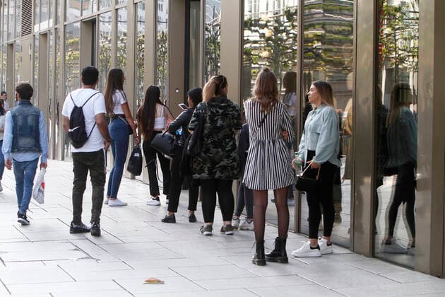 Queue of customers who want to enter a shop in the shopping street and pedestrian zone Zeil in downtown Frankfurt, Hesse, Germany The shop only allows a certain number of customers to enter the shop for reasons of distance