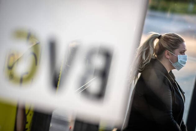 A woman with a mouth-nose mask at a bus stop of the BVG in Berlin From Monday, 27 April 2020, a mask is mandatory in public transport.