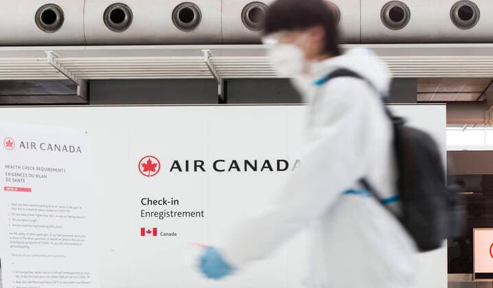(200427) -- TORONTO, April 27, 2020 -- A traveller wearing protective gear walks by the Air Canada check-in counters at Pearson International Airport in Toronto, Canada, April 27, 2020. Air Canada suspended all scheduled flights to the United States for four weeks starting on Monday. As of Monday afternoon, there were 48,230 confirmed COVID-19 cases in Canada and 2,701 deaths. (Photo by Xinhua) CANADA-TORONTO-COVID-19-AIR CANADA-FLIGHTS TO U.S.-SUSPENSION ZouxZheng 