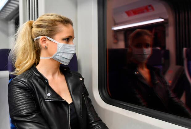 Woman with face mask, sitting in train, reflected in S Bahn, corona crisis, Stuttgart, Baden Württemberg, Germany Coronavirus
