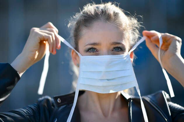 Woman putting on face mask, portrait, corona crisis, Stuttgart, Baden Württemberg, Germany Coronavirus