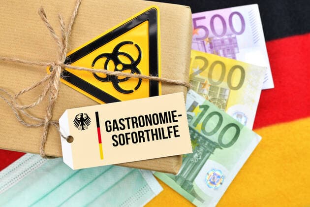PHOTOMONTAGE, package with biohazard sign on German flag with label and the inscription Gastronomie Soforthilfe ** NUR FUER REDAKTIONELLE ZWECKE ** EDITORIAL USE ONLY **