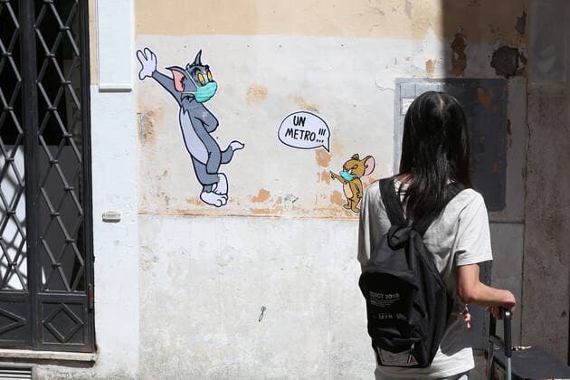 Mauro Pallotta, aka Maupal, created a new mural in Borgo Pio, a few meters from the Vatican and St. Peter s square. The work depicts the characters of the cartoon Tom & Jerry. Both Tom, the cat, and Jerry, the mouse, wear a mask. Jerry, who is usually chased by Tom, scolds the other and tells him to respect the safety distance, one meter, in the photo a boy takes the mural with the i-pod (Alberto Lo Bianco Fotogramma, Rome - 2020-04-30) p.s. la foto e utilizzabile nel rispetto del contesto in cui e stata scattata, e senza intento diffamatorio del decoro delle persone rappresentate  Copyright: xAlbertoxLoxBiancox xFOTOGRAMMAx