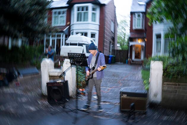 (200501) -- MANCHESTER, May 1, 2020 (Xinhua) -- A resident of the Wood Road in Chorlton plays an instrument in a street concert as part of the weekly Clap for Our Carers in Manchester, Britain, on April 30, 2020. (Photo by Jon Super Xinhua) BRITAIN-MANCHESTER-COVID-19-STREET CONCERT 