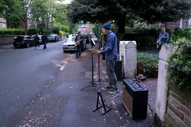(200501) -- MANCHESTER, May 1, 2020 (Xinhua) -- Residents of the Wood Road in Chorlton play instruments in a street concert as part of the weekly Clap for Our Carers in Manchester, Britain, on April 30, 2020. (Photo by Jon Super Xinhua) BRITAIN-MANCHESTER-COVID-19-STREET CONCERT 