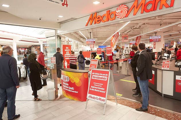 - Wien 02.05.2020 - Coronavirus Krise - Nach fast 7 Wochen Coronavirus-Beschränkungen dürfen heute auch Einkaufszentren, Friseure und Geschäfte mit mehr als 400 Quadratmetern Verkaufsfläche wieder aufmachen, darunter die großen Elektrohändler, Modeketten, Möbelhäuser und Sportartikelhändler. Es gilt die Maskenpflicht und Abstand halten. Zur Wiedereröffnung winken großzügige Rabatte. Die Lager sind randvoll. PHOTO: Grosser, aber geregelter Andrang am Eingang dieses Elektromarkts in der Lugner City. Vienna, Austria - Coronavirus Crisis - After almost 7 weeks of coronavirus restrictions, shopping centers, hairdressers and shops with more than 400 square meters of retail space are now allowed to reopen, including the large electrical retailers, fashion chains, furniture stores and sporting goods retailers. It is mandatory to wear a mas 