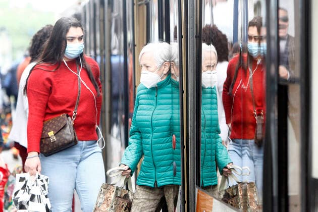 Passengers with breathing masks at a tram stop with tram train of the RNV Rhein Neckar Verkehrsverbund s in the city centre of Mannheim, Baden Württemberg, Germany