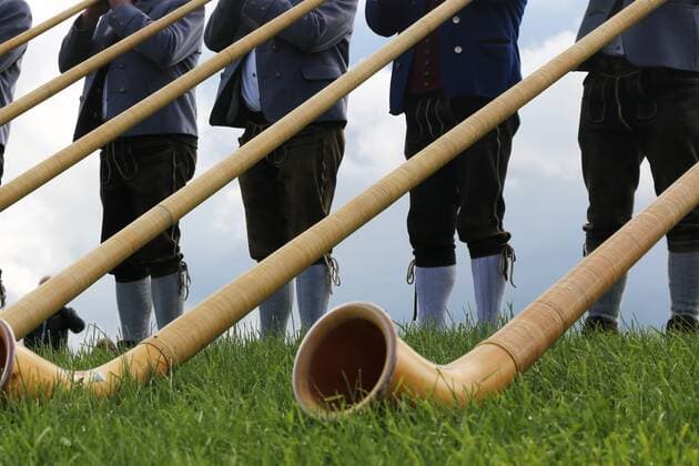 Alphornbläser in den Alpen. Traditionelles Blasinstrument im Alpenraum, vor allem in der Schweiz (hier allerdings Allgäu) *** Alphorn player in the Alps Traditional wind instrument in the Alps, especially in Switzerland, but here in Allgäu
