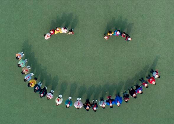 (200509) -- BEIJING, May 9, 2020 -- Aerial photo taken on May 8, 2020 shows primary school students forming a smile face on the playground in Taizhou, east China s Jiangsu Province. World Smile Day is celebrated on May 8 every year. (Photo by Xinhua) XINHUA PHOTOS OF THE DAY TangxDehong 