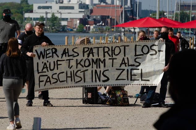 Coronavirus, Demonstration against Corona Measures Counter-demonstrators hold up a banner with the inscription Whoever starts out as a patriot will finish as a fascist , on 09 05 2020 in Flensburg, Hafen, Hafenspitze