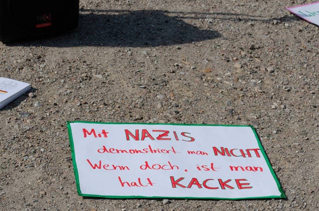 Coronavirus, demonstration against corona measures banner on sandy soil and inscription With Nazis you dont demonstrate If you do, youre shit, on 09 05 2020 in Flensburg, port, tip of the port