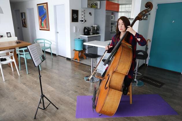 Photograph dated May 9, 2020 in which the bassist of the Bogota Philharmonic Orchestra Monica Suarez is seen while playing her instrument and recorded with her mobile phone in the living room of her apartment in Bogota, Colombia 10 May 2020. In these days of pandemic and confinement, the musicians of the Bogota Philharmonic Orchestra have taken advantage of technology and social networks to express their art and present themselves to an audience that cannot be crowded to see them live and direct. The COVID-19 changes the score to the musicians of the Bogota Philharmonic !ACHTUNG: NUR REDAKTIONELLE NUTZUNG!  Copyright: xCarlosxOrtegax AME8910 20200510-637247324535136786