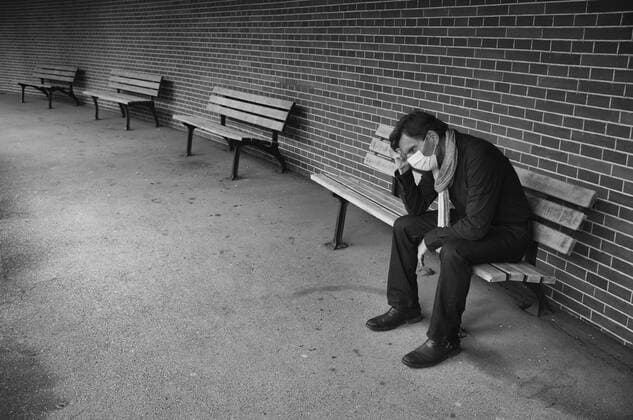 Man with face mask, sitting on a bench, thoughtful, corona crisis, Stuttgart, Baden Württemberg, Germany Coronavirus