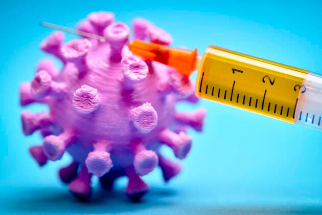 Coronavirus model with vaccination syringe, symbol photo for Covid 19 vaccine ** NUR FUER REDAKTIONELLE ZWECKE ** EDITORIAL USE ONLY **