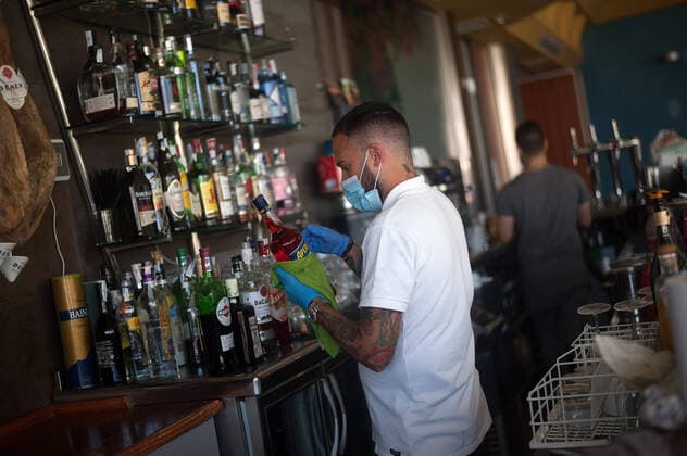 May 13, 2020, Malaga, Spain: An employee cleaning a bottle inside Godoy shellfish bar before its reopening during the partial lockdown after the beginning of phase 1 in some cities..Spain is going through the plan of down-scaling towards a new normality by relaxing measures that resulted from the COVID-19 outbreak, cities like Madrid, Barcelona, Malaga or Granada continue in phase 0 due to the epidemiological opinions of sanitary authorities. Malaga Spain - ZUMAs197 20200513_zab_s197_003 Copyright: xJesusxMeridax