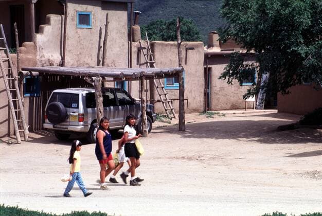 1 Traveling Indian children in Taos Pueblo in New Mexico, Indian village of the Taos Indians, earth-colored Adobe architectural style straw, earth water, about 150 p Copyright: xBriganiArt ArtistxAtxWork Heinrix 00024059_00024059