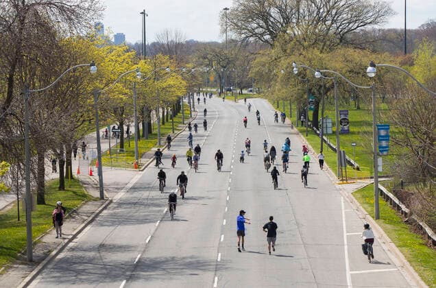 (200516) -- TORONTO, May 16, 2020 -- People jog and cycle along a road in Toronto, Canada, on May 16, 2020. The City of Toronto transformed sections on major roads into quiet streets to provide more space for people to be physically active and improve physical distancing due to the COVID-19 outbreak during the long weekend. (Photo by Xinhua) CANADA-TORONTO-COVID-19-MEASURES-QUIET STREETS ZouxZheng 