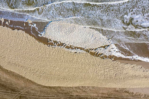 15 05 2020 , Netherlands , Scheveningen , 5 surfers die on Monday evening off the coast of the town of Scheveningen Aerial photograph with a drone of foam Sea foam on the beach of Scheveningen