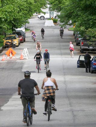 (200525) -- VANCOUVER, May 25, 2020 (Xinhua) -- People cycle and jog on the Slow Street at a road in Vancouver, Canada, May 24, 2020. City of Vancouver unveiled the Slow Streets program allowing people to walk and bike on the roads with limited local traffic in order to provide more space to the people to maintain physical distance. (Photo by Liang Sen Xinhua) CANADA-VANCOUVER-COVID-19-SLOW STREETS 
