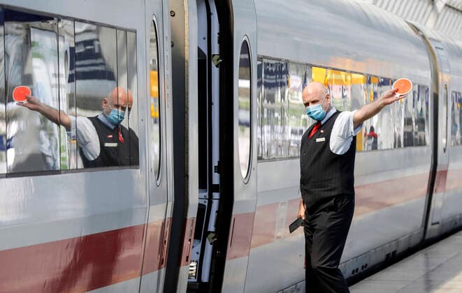 Deutsche Bahn Coronavirus Berlin, DEU, 27 05 2020 A train attendant wearing a face mask gives the train driver the departure sign at Berlin Spandau station Federal Minister of Transport, Deutsche Bahn and the Works Council form an alliance for our railway
