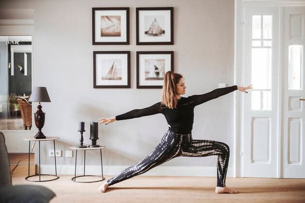 Creative Highlights Symbolfotos Woman practising yoga at home, warrior pose model released Symbolfoto property released DAWF01426