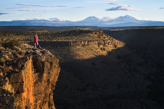 Woman standing on edge of cliff overlooking canyon and mountains Bend, OR, United States CR_ADMC200413-359408-01,model released, Symbolfoto