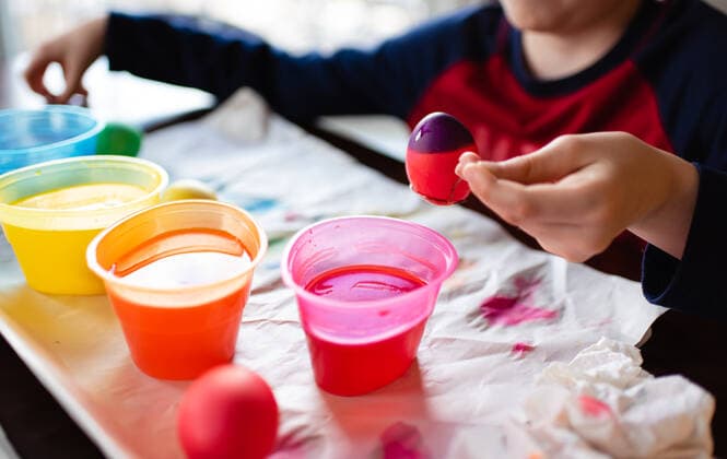 Close up of boy dipping an egg into dye to color it for Easter. Kingston, ON, Canada CR_DOHO200501G-369238-01,model released, Symbolfoto