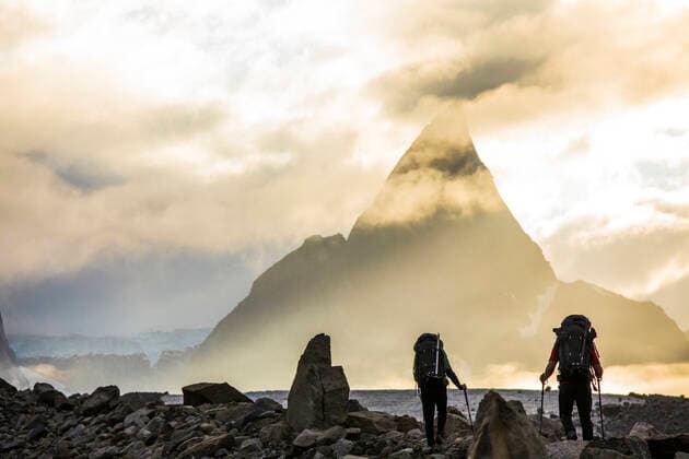Rear view of backpackers approaching dramatic mountain, Mt. Loki Pangnirtung, NU, Canada CR_JDIP200518-319442-01,model released, Symbolfoto