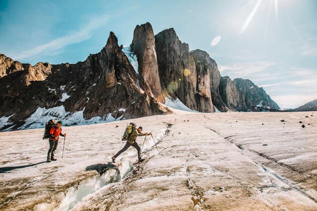 Mounatineer crosses a glacial crevasse on a sunny day, Baffin Island. Pangnirtung, NU, Canada CR_JDIP200518-319620-01,model released, Symbolfoto