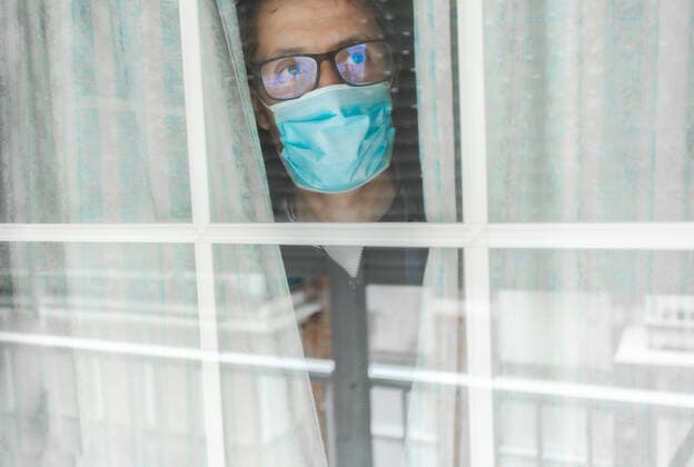 Middle-aged man in the medical mask is quarantined in the hospital and pressed her forehead against the window Seville, AL, Spain CR_JURA200514-369031-01,model released, Symbolfoto