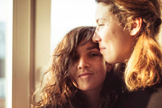 feminine lesbian couple watch the sun set through window in warm loft CR_PIDODS200410A-326440-01,model released, Symbolfoto