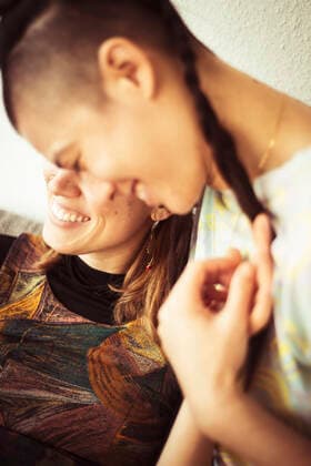 Same sex lesbian couple stay at home and cuddle smiling in warm light CR_PIDODS200410A-326442-01,model released, Symbolfoto