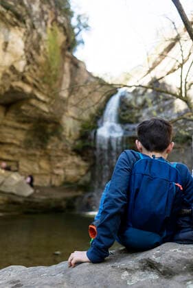 Back view of two young teenagers sitting on rock against waterfall Cantonigròs, CT, Spain CR_RAFE200428-349528-01,model released, Symbolfoto