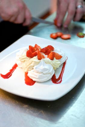 chef preparing pavlova with fresh strawberries and cream Egham, England, United Kingdom CR_THHE200407A-344891-01,model released, Symbolfoto ,property released