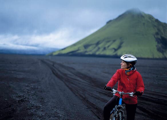 woman riding her bike on Maelifellssandur in the Icelandic highlands Kirkjubæjarklaustur, Iceland CR_THHE200415A-352099-01,model released, Symbolfoto