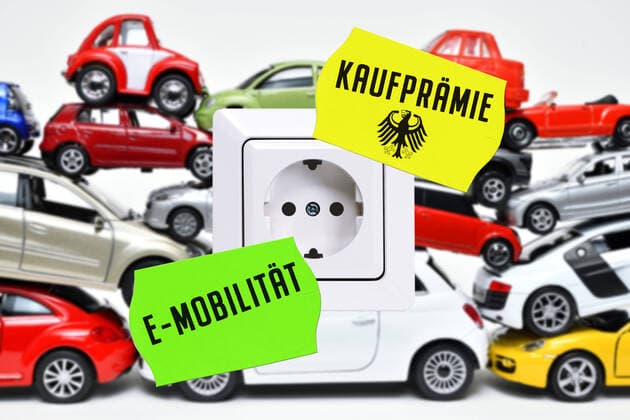PHOTOMONTAGE, Stacked toy cars with power socket, Symbol photo Car bonus for electric cars ** NUR FUER REDAKTIONELLE ZWECKE ** EDITORIAL USE ONLY **