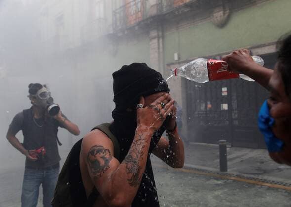 A young man pours water on the face of another to calm the effect of tear gas on the outskirts of the Government Palace of Jalisco this Thursday, during a protest for the death of Giovanni Lopez, beaten by police from Ixtlahuacan de los Membrillos, in the city of Guadalajara, Mexico 4 June 2020. At least 20 people arrested and two burned patrols left protests in the Mexican city of Guadalajara on Thursday against police abuse of a young man who died after being arrested for not wearing face masks in the middle of the coronavirus pandemic. Twenty detainees and two patrols burned in protests against police abuse !ACHTUNG: NUR REDAKTIONELLE NUTZUNG!  Copyright: xFranciscoxGuascox MEX2122 20200605-637269354284231392