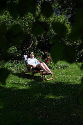 Young woman model released sunbathing on a garden lounger in a garden