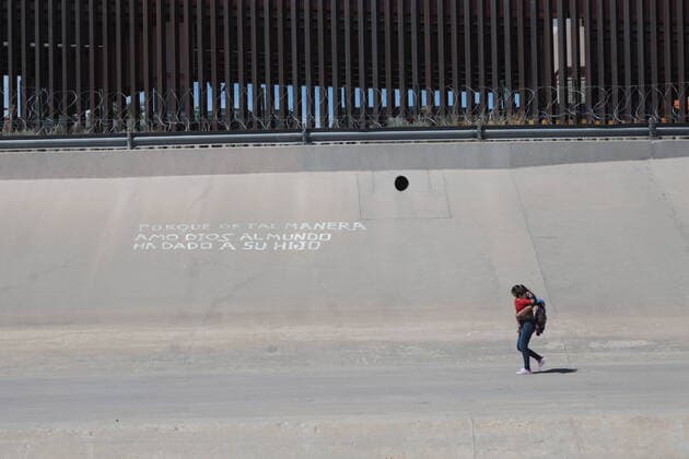 (200620) -- CIUDAD JUAREZ, June 20, 2020 (Xinhua) -- Honduran migrant Tania, carrying her son Erick in her arms, wanders around the border wall between Mexico and the United States in Ciudad Juarez, Mexico, June 18, 2020. The U.S. administration led by President Donald Trump is taking advantage of the COVID-19 pandemic to tighten the migration and asylum policies, said experts from Latin America. Tania, coming all the way from her home town in Honduras of Central America and hoping to enter the United States legally, now faces an unknown future. (Photo by David Peinado Xinhua) MEXICO-CIUDAD JUAREZ-COVID-19-MIGRANTS