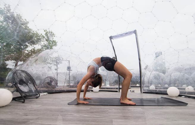 (200623) -- TORONTO, June 23, 2020 -- A woman performs a yoga posture in a dome in Toronto, Canada, on June 22, 2020. A new pop-up event called Hot Yoga has been held in Toronto from June 21 to July 31. People can take part in yoga classes inside their own private dome to prevent the spread of COVID-19. (Photo by Xinhua) CANADA-TORONTO-COVID-19-YOGA DOMES ZouxZheng 