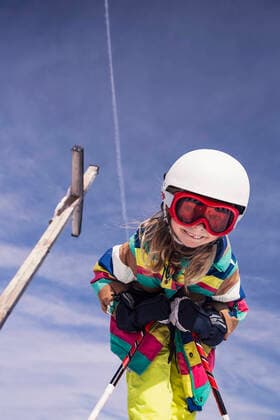 Low angle view of excited girl skiing against sky during winter at Spitzingsee, Bavaria, Germany model released Symbolfoto DHEF00158