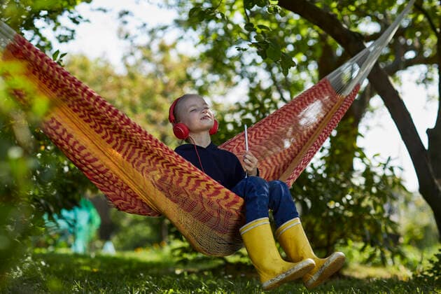 Girl with smartphone and headphones in hammock listening to music model released Symbolfoto property released MCF00841