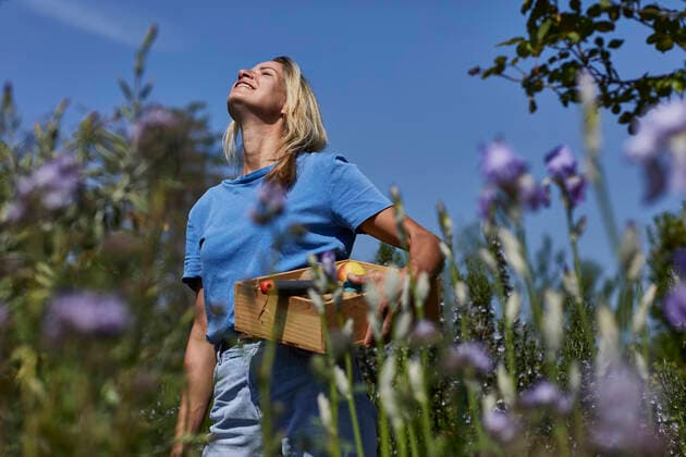 Smiling woman holding a crate in allotment garden model released Symbolfoto property released MCF00892