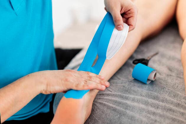 Visually impaired physiotherapist applying Kinesio tape on boy s hand in clinic model released Symbolfoto property released MRRF00063