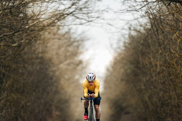 Young man riding racing bicycle amidst bare trees model released Symbolfoto MTBF00401