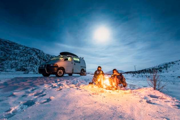 Campers at camp fire in winter landscape in polar night, Kilpisjaervi, Enontekioe, Finland model released Symbolfoto WVF01531