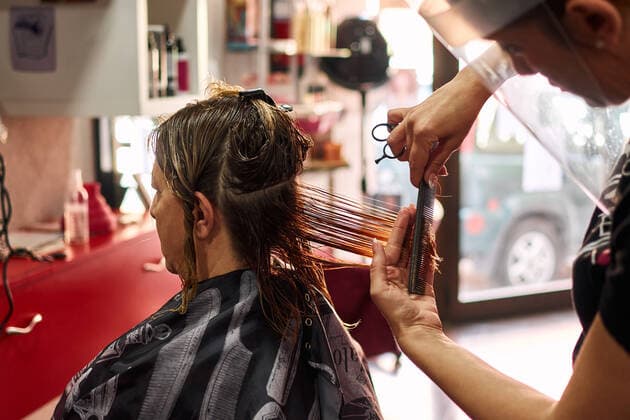A close-up of a hairdresser cutting client s hair with a face shield Villena, Valencian Community, Spain CR_CRBL200605-417610-01 ,model released, Symbolfoto